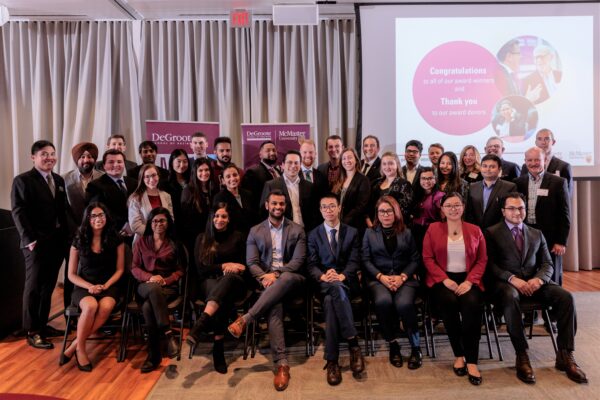 Photo of group of smiling men and women in a banquet hall with the words "Congratulations to all of our award winners and thank you to our award donors" 